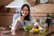 © ADDICTIVE STOCK - Content young ethnic woman eating salad from bowl in kitchen