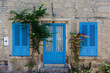 View of old, historical, traditional stone house with blue colored door and windows in famous, touristic Aegean town called Alacati. It is a village of Cesme, Turkey. It is a sunny summer day