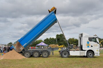 Camion benne qui déverse du sable