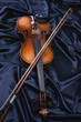 © SuperStock - Violin and a bow on blue fabric