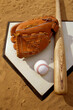 © SuperStock - Baseball bat with a glove and a baseball on the home base