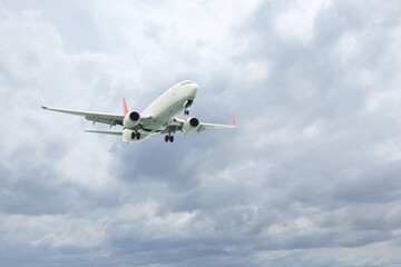 Wall Mural - Airplane flying high in cloudy sky. Modern aircraft