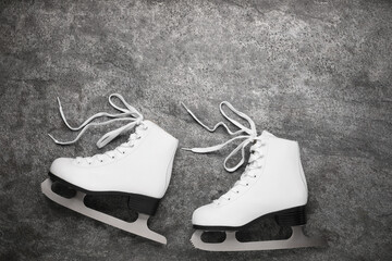Wall Mural - pair of white ice skates on grey background, top view