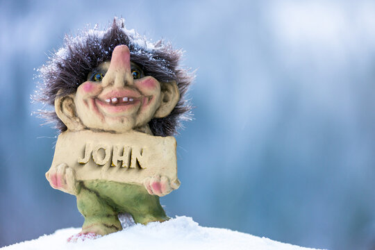 Smiling troll holding a name plate with the name john chiseled out in stone. Popular name concept.