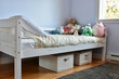 Modern child's room with favourite stuffies on bed and simple storage solution ideas for toys under the bed