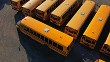 View On Parked American Buses In Canada Waiting For The Educational Season. Yellow School Buses In Parking At Golden Hour.