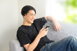 canvas print picture - Good looking man smiling at his phone.
