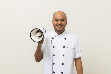 Wall Mural - Shout out loud order excited face with mega phone Young handsome asian man boss chef in uniform command order the staff for menu on isolated. Cooking indian man chef in kitchen restaurant and hotel.