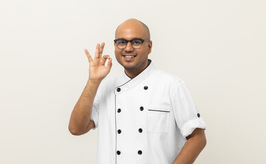 Wall Mural - Casual Young handsome asian man chef in uniform standing various posting taste delight delicious hand gesture. Cooking indian man Occupation chef or baker People in kitchen restaurant and hotel.