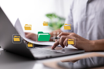Leinwandbilder - Paperless office idea based on electronic documents. A businessman types on a laptop keyboard while looking at icons for digital documents on a computer screen.
