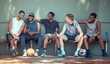 © David L/peopleimages.com - Basketball, sport and friends with a team of men sitting on a bench after training, practice or a game. Teamwork, phone and exercise with a group of basket ball players outside on a sports court