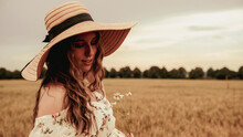 Beauty Romantic Girl Outdoors. Happy Young Woman In Sun Hat In Summer Wheat Field At Sunset. Copy Space, Sunset, Flare Light, Summer Season. Boho Chic Style.