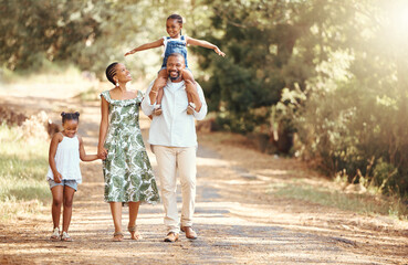 happy black family bonding on an outdoor work in a park, loving and having fun together. african ame