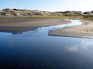 Wall Mural - Tributary joins a larger river mainstem forming confluence