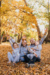 © Strelciuc - Portrait of a happy beautiful family posing while having fun in autumn forest playing and throwing leaves. Love, relationship, family, season and people concept