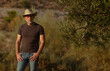 © WeeKwong - Portrait of adult man in cowboy hat standing in field during sunset