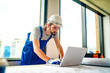 © FotoArtist - Portrait of male worker professional electrician in uniform installing electrical outlet in apartment after renovation work. Manual work, maintenance, occupation concept. Side view