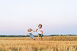 © Надежда Урюпина - Happy and free people, children run through the beveled field of wheat