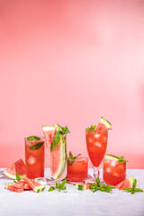 Wall Mural - Different elegant glasses with watermelon cocktail. Splash, splatter, water drops on the pink background