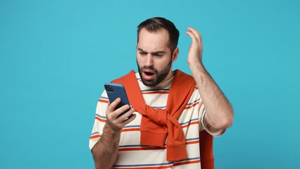 Wall Mural - Upset young brunet man 20s wears striped t-shirt using mobile cell phone swear show thumb down hears fake news unexpected rumor has some problems isolated on plain pastel light blue background studio