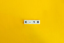 K-18 (Kindergarten To Master’s Degree) Education Program. Letter Tiles On Yellow Background. Minimal Aesthetics.