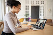 © muse studio - A woman uses a laptop makes a report video communication chat online