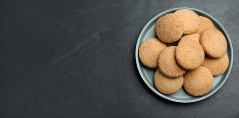 Delicious sugar cookies on black table, top view. Space for text