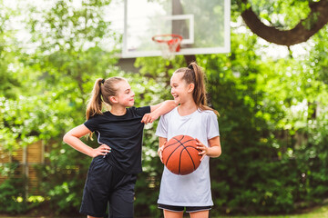 two girl child in sportswear playing basketball game