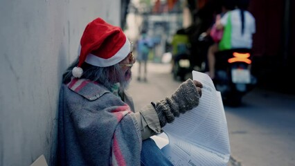 Wall Mural - 4K, Asian homeless old man read a newspaper in the corner of the building to look for a job, a man who waits for hope and help because there is no home and no job stay hungry