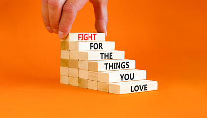 Fight for love symbol. Concept words Fight for the things you love on wooden blocks on a beautiful orange table orange background. Businessman hand. Business motivational and fight for love concept.