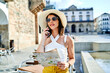 © ADDICTIVE STOCK - Smiling tourist with paper map talking on cellphone in city