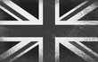 a monochrom full frame image of an old stained dirty union jack british flag with dark crumpled edges.black british flag. vector design grungy textured black britain flag.