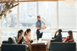 © Cavan Images - Businessman holding blueprint during meeting with colleagues