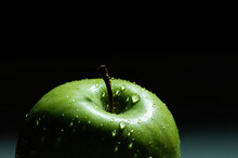 Close-up Of Wet Green Apple Against Black Background