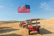 American Flag On A Trailer Behind A Tractor.