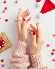 Wall Mural - Female hand with manicure on white background. Christmas Valentines day trendy shiny nail design