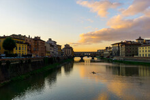 Ponte Vecchio over Arno river against sky during sunset in city