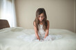 © Cavan Images - Thoughtful girl relaxing on bed at home