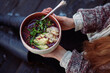 © Cavan Images - Midsection of woman holding food in bowl