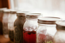 Close-up Of Preserves In Jars Arranged On Window Sill At Home