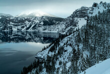 Scenic View Of Crater Lake By Snow Covered Mountains