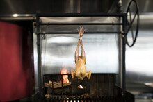 Chicken Meat Hanging Over Barbecue Grill