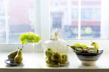 Various Fruits In Containers On Window Sill