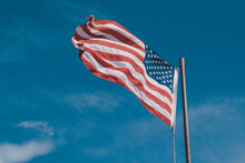 Low Angle View Of American Flag Against Blue Sky
