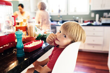 Portrait Of Cute Boy Eating Popcorn With Grandmother In Background