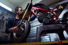 Mechanic Repairing Motorcycle At Garage
