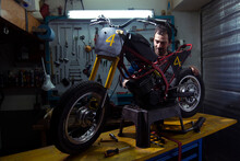 Mechanic Examining Motorcycle In Auto Repair Shop