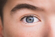© Cavan Images - Macro shot portrait of boy with gray eye