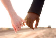 Cropped Hands Of Newlywed Couple Holding Little Fingers While Pinky Promising At Desert