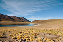 Scenic View Of Lake By Mountains At Desert Against Sky